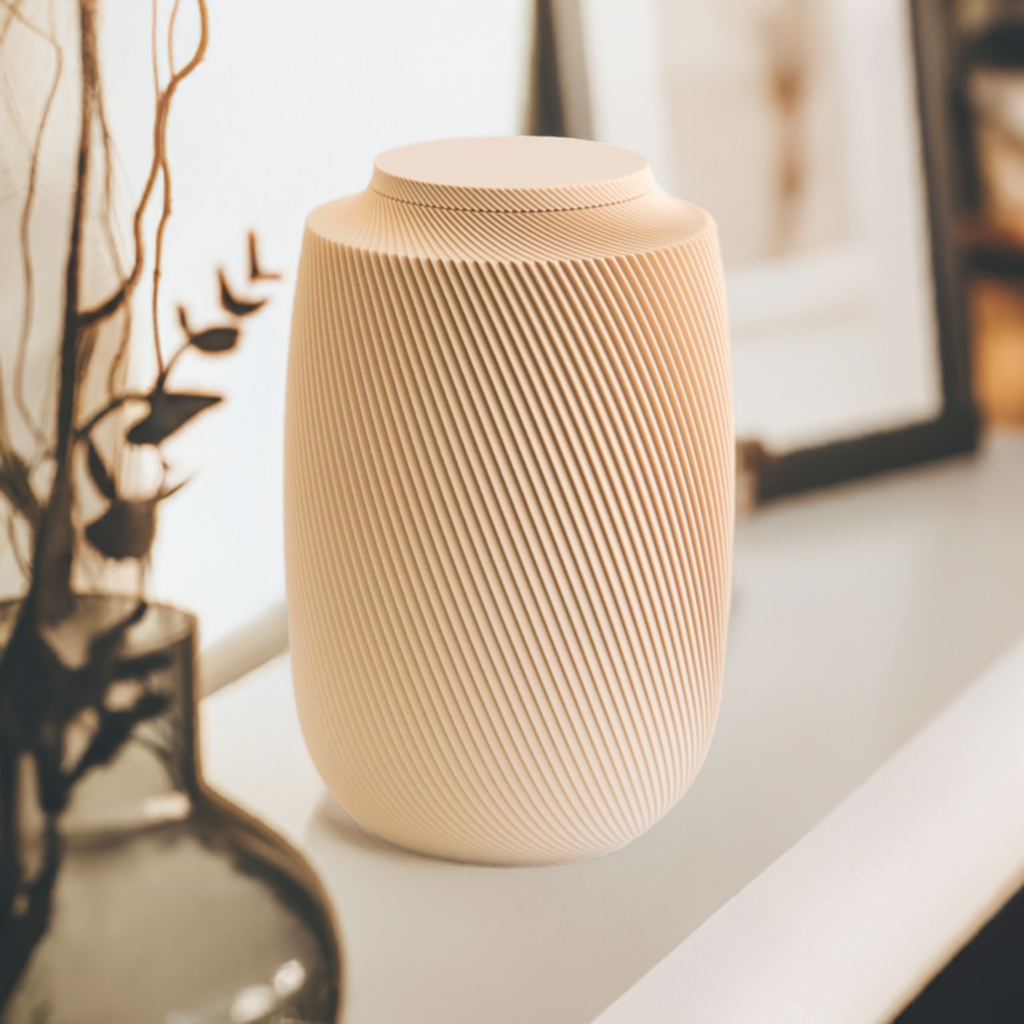 Aspen cremation urn in tan with modern sculpted texture, displayed on a shelf with warm decorative accents.