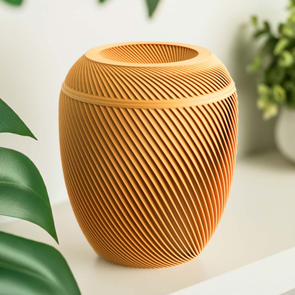 A mustard yellow Laurel Urn with a spiral design, placed on a shelf with a plant and books in the background.