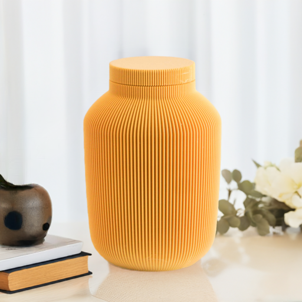 Willow cremation urn in Mustard with modern vertical sculpted texture, displayed with books and soft floral décor.